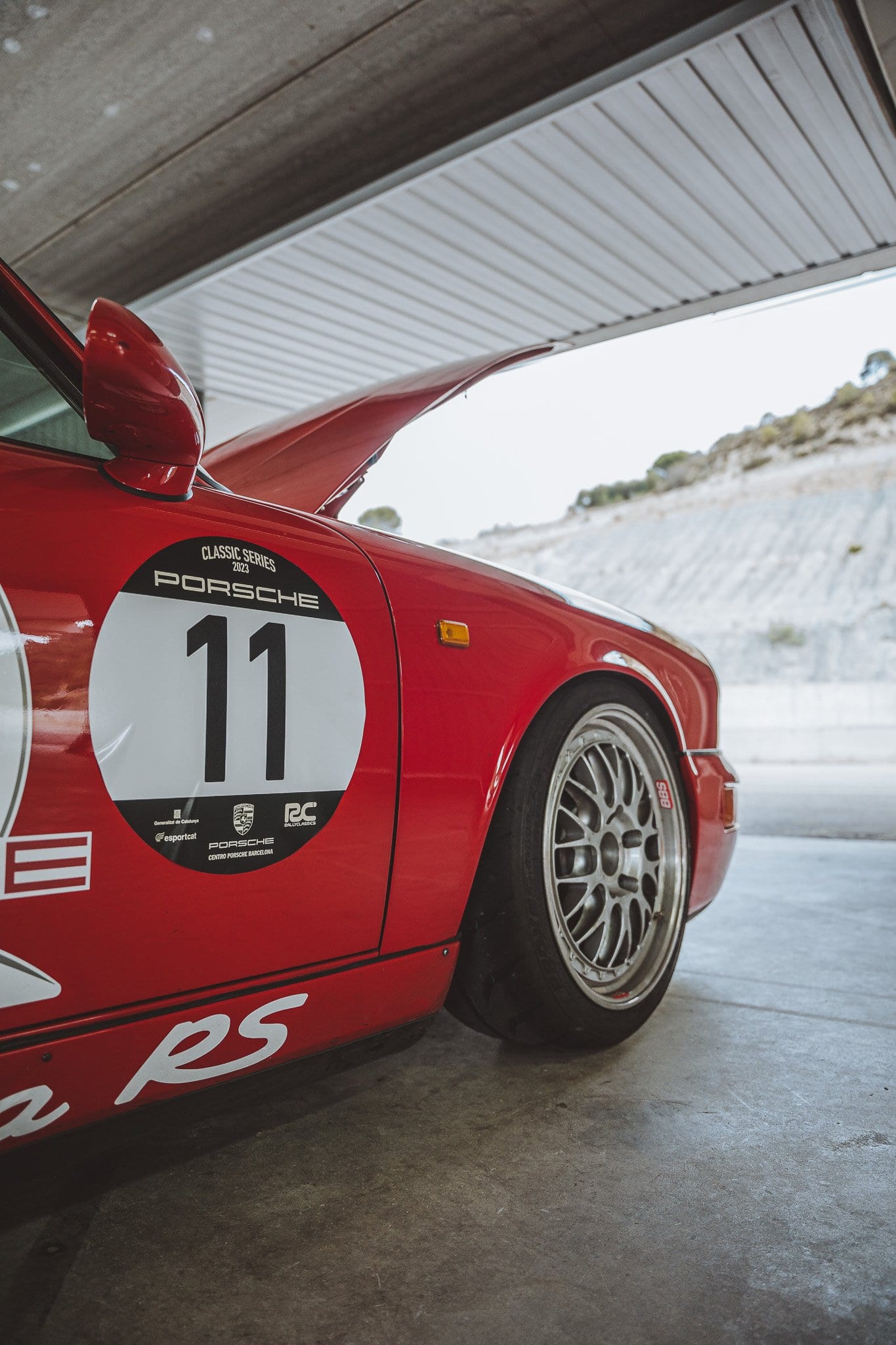 El 964 Carrera RS rojo con el dorsal 11, aparcado en el box del circuito