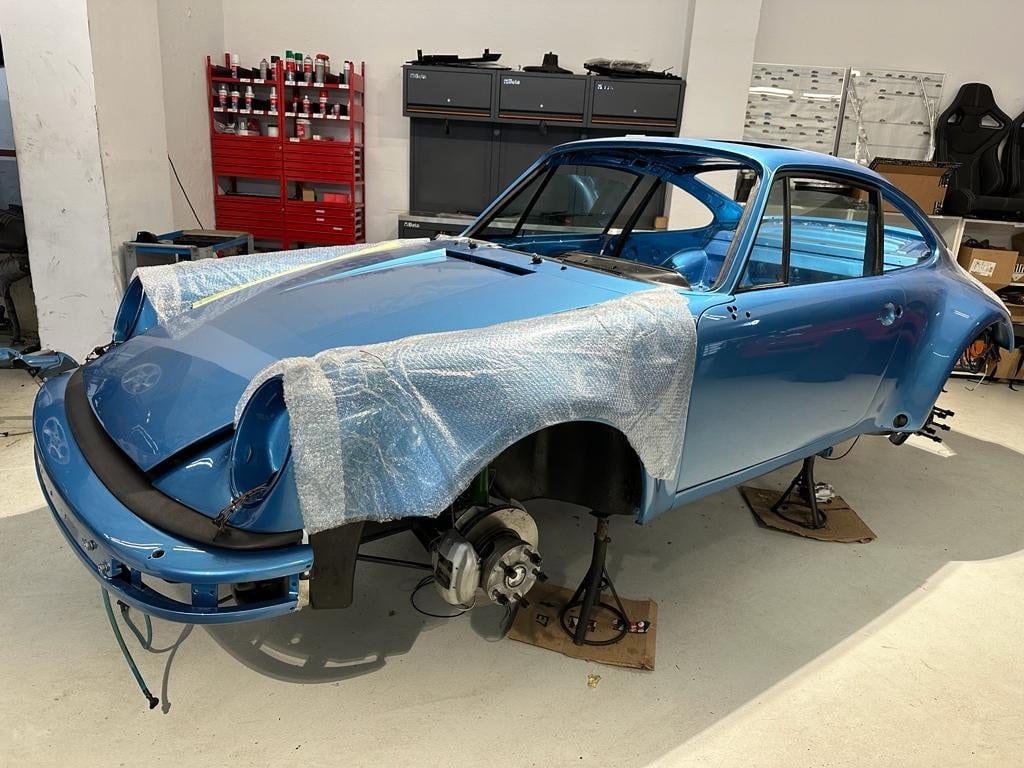 La 930 Turbo bleue à l'atelier, masquée et sans roues ni vitrage