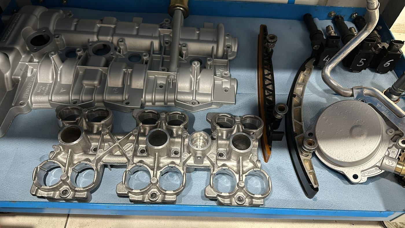 M96 cylinder head, timing chain and manifolds laid out on the tray