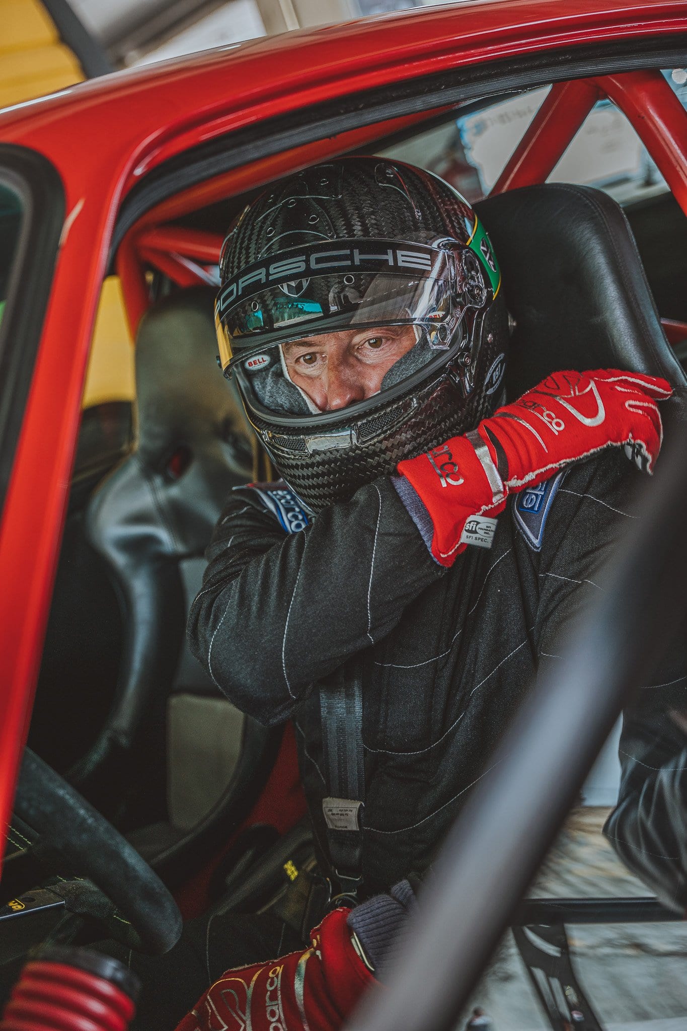 El piloto ya sentado en el 964 rojo, con el casco y los guantes puestos