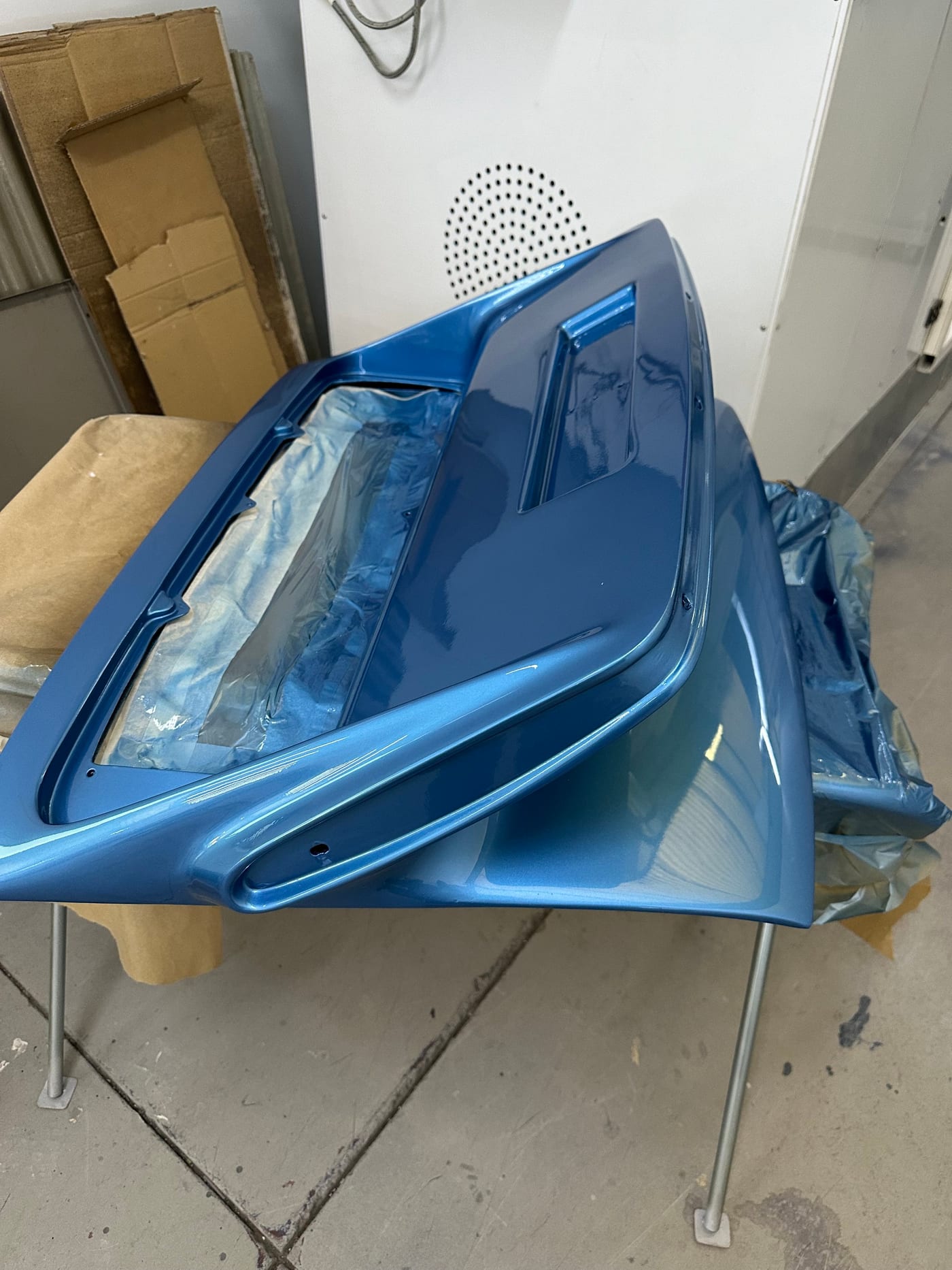 Le capot avant de la 930 Turbo peint en bleu, posé sur des tréteaux