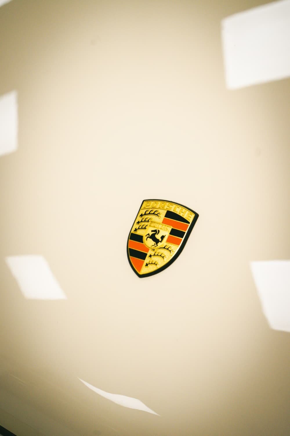 El escudo Porsche sobre el capó crema del PA10/01