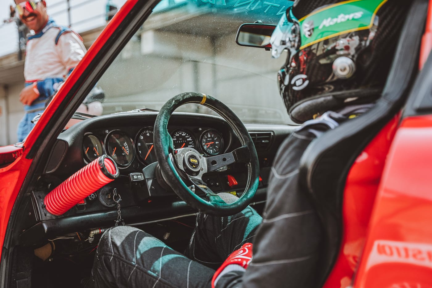 Interior del 964 de competición con el volante, el extintor y el casco
