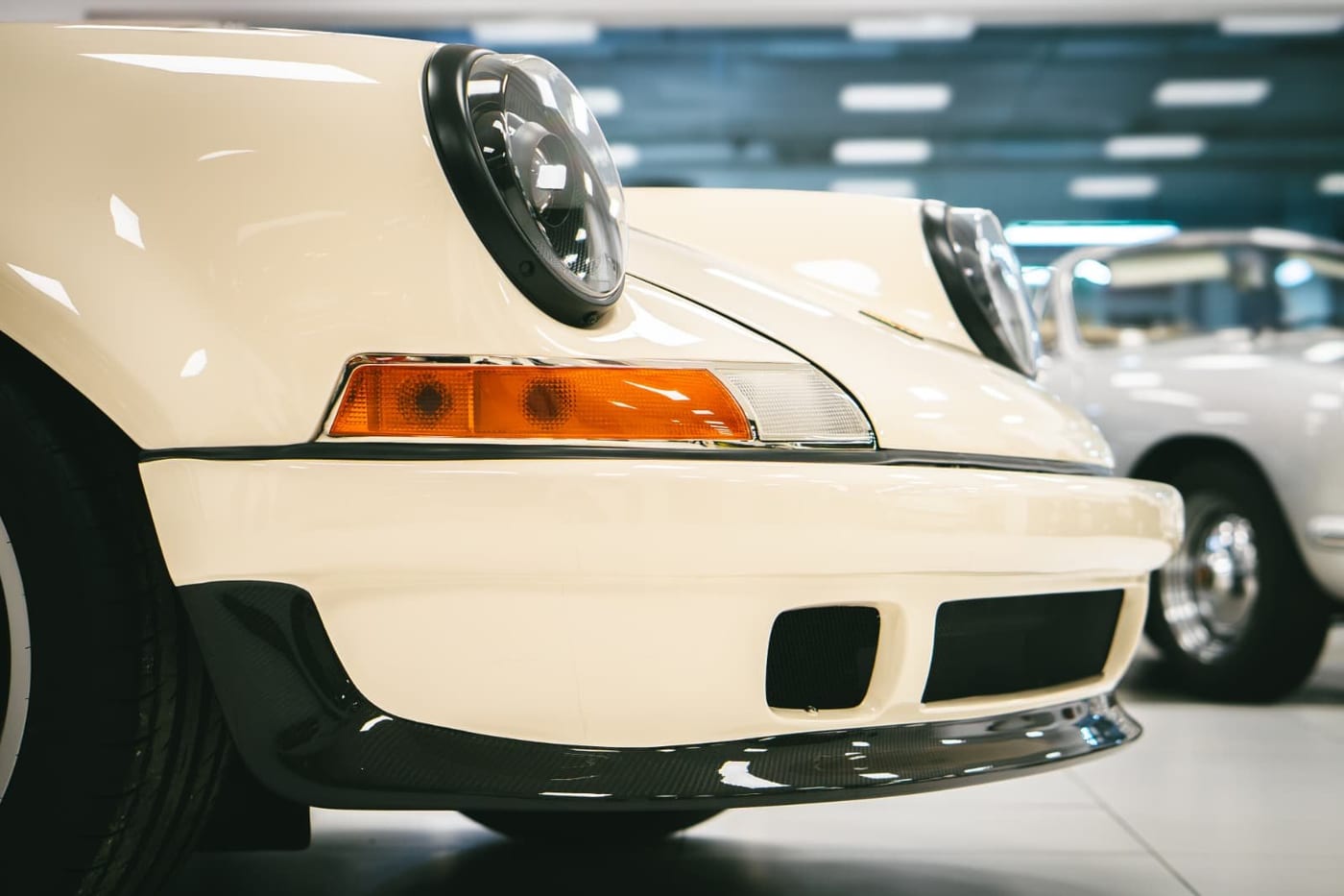 Frontal del 911 PA10 en color crema, con el paragolpes de fibra y los intermitentes ámbar