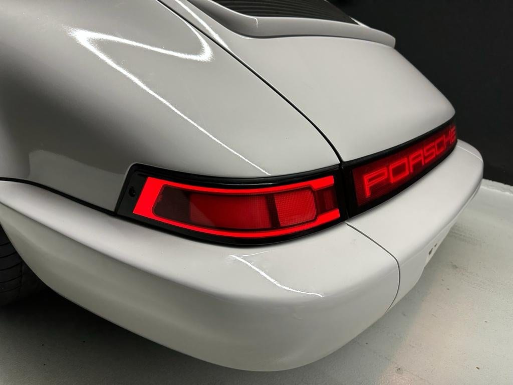 Piloto trasero LED encendido en un 964 blanco, con la banda PORSCHE iluminada