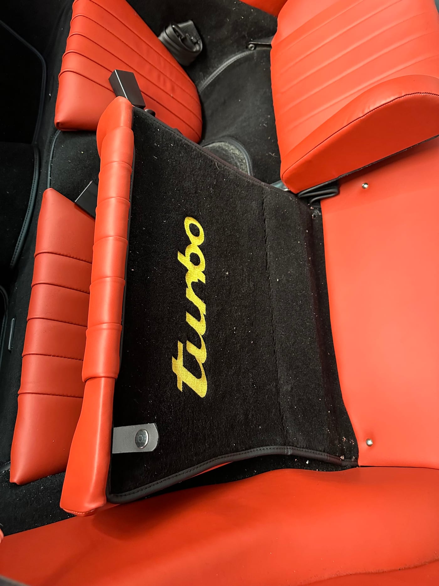 Tapis de sol avec le lettrage turbo brodé en jaune sur la sellerie rouge
