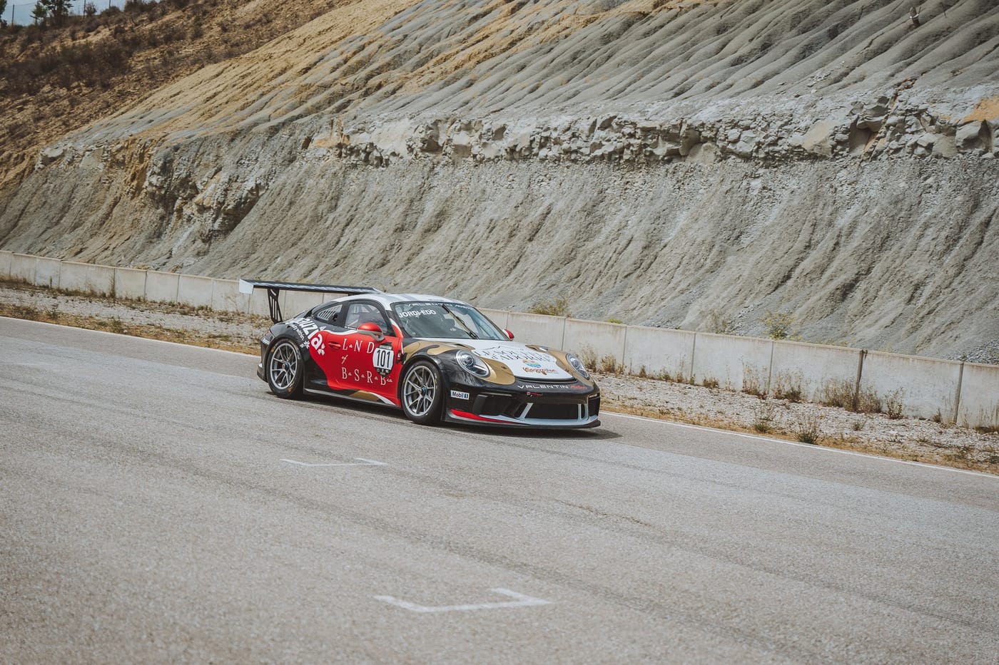 El 991 Cup rodando en pista, con el talud de roca al fondo