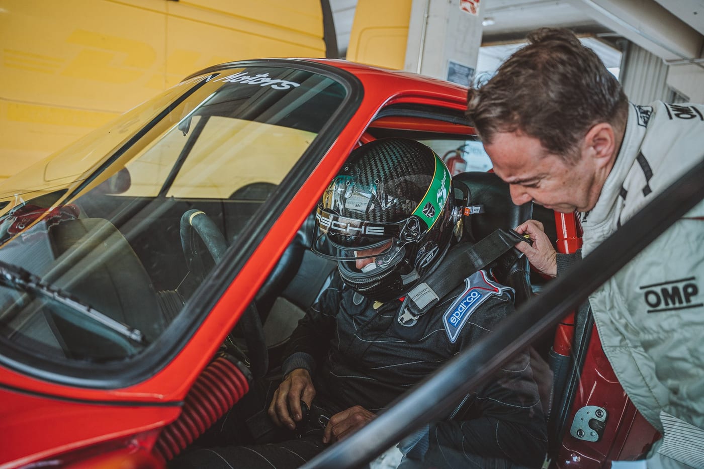 Un piloto se coloca el casco dentro del 964 de competición, con la jaula a la vista