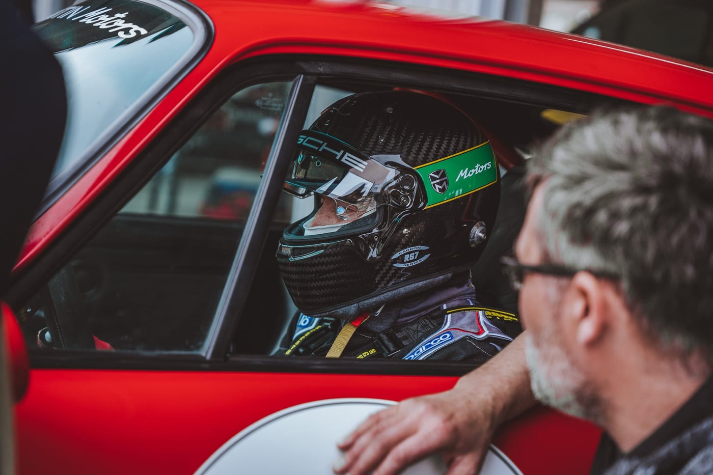 El piloto en el 964 rojo mientras alguien le habla desde fuera