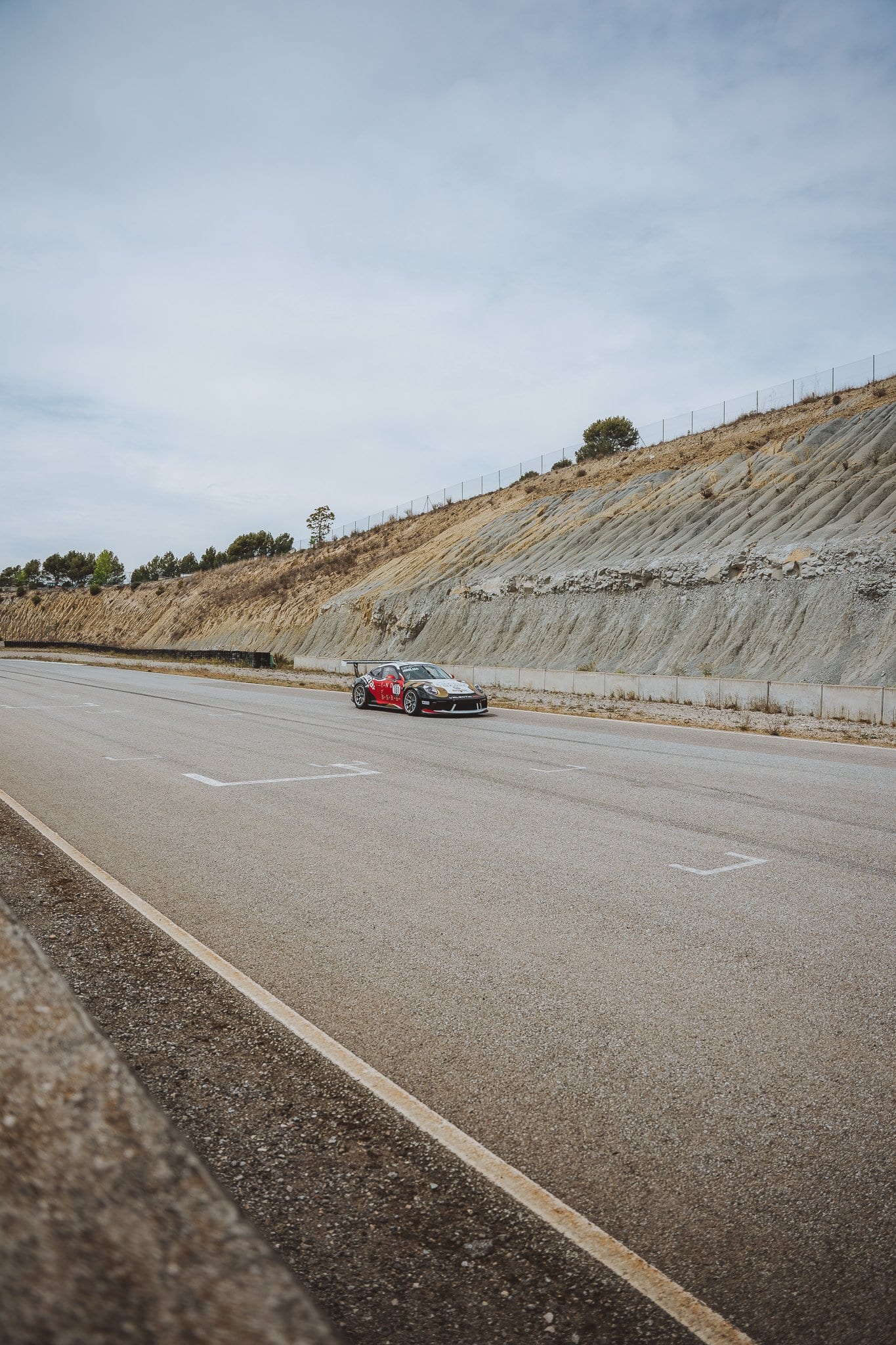 El 964 rojo pasando por la recta, visto desde el muro de boxes