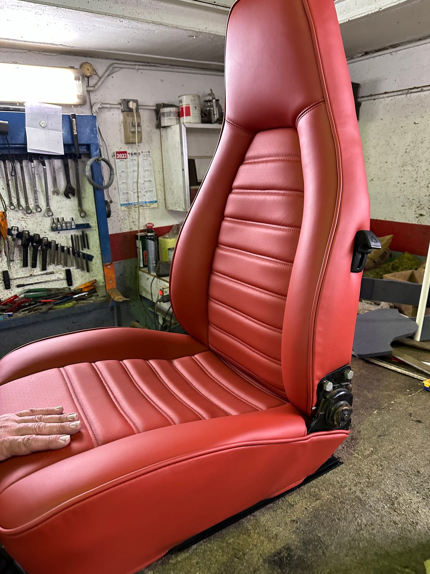 Siège de la 930 Turbo fraîchement garni en cuir rouge, à l'atelier de sellerie