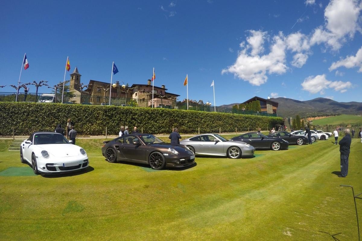 Els Porsche de The Grand Tour exposats sobre la gespa davant d'un edifici de pedra amb banderes