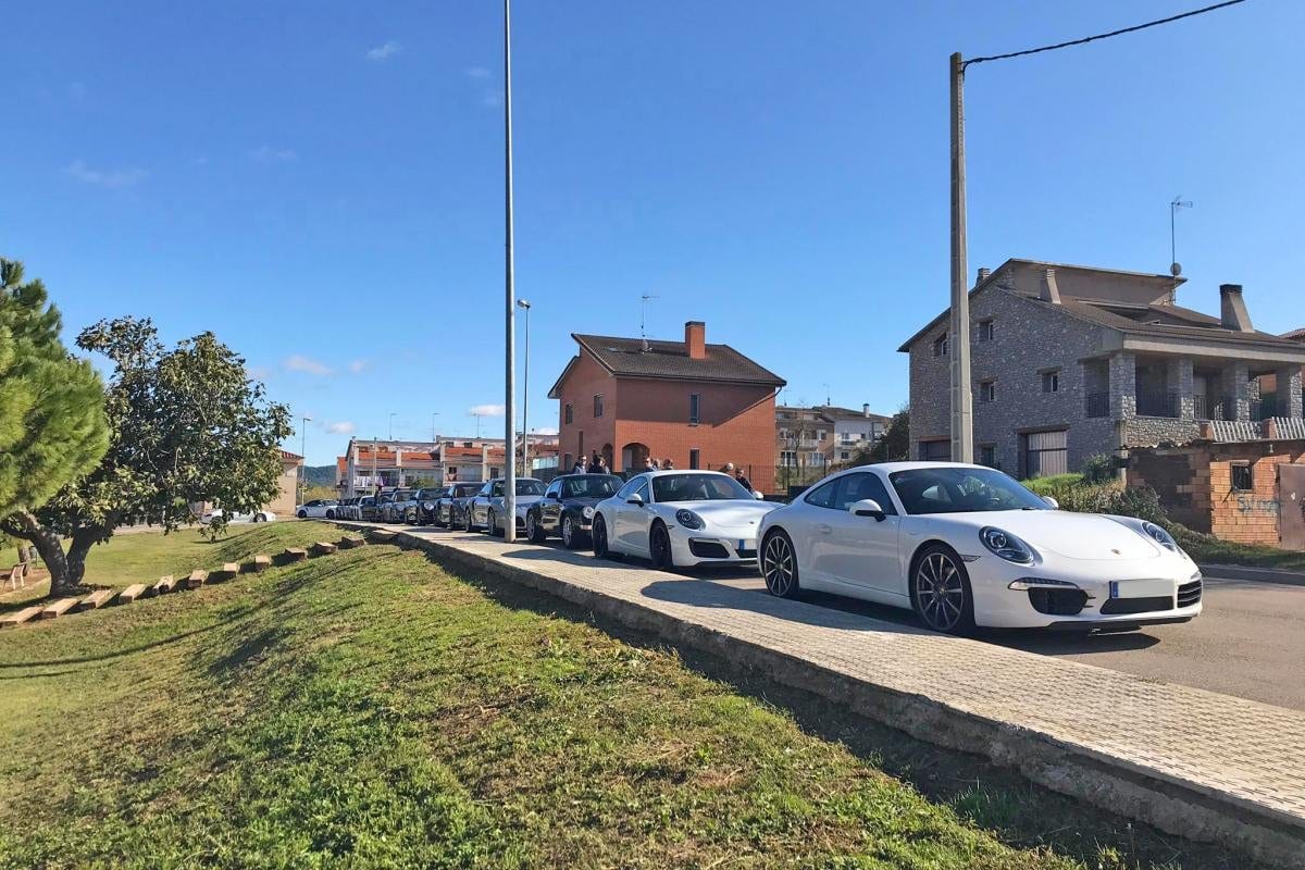 Filera de Porsche aparcats en un carrer durant la sortida 9/11 Rebel Ride, amb un 991 Carrera blanc en primer pla