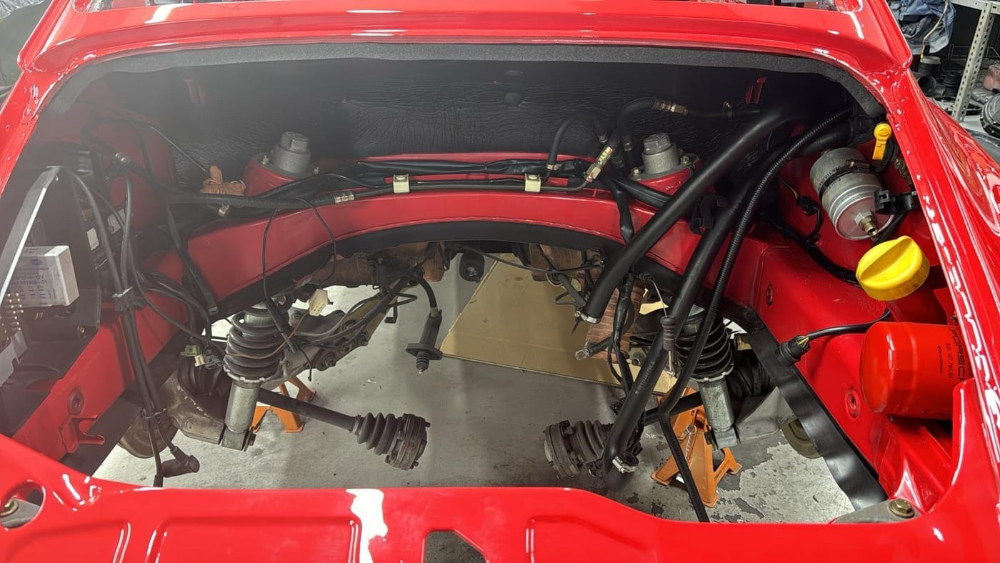 Vano motor del 964 rojo con la suspensión trasera y las transmisiones a la vista