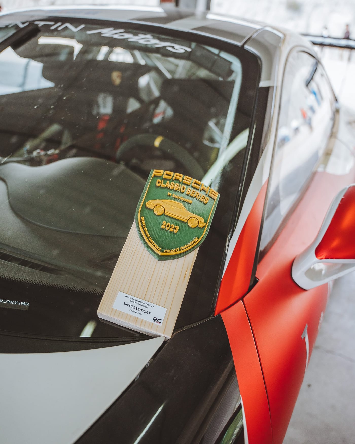 Detalle del trofeo de la Porsche Classic Series 2023 apoyado en el coche