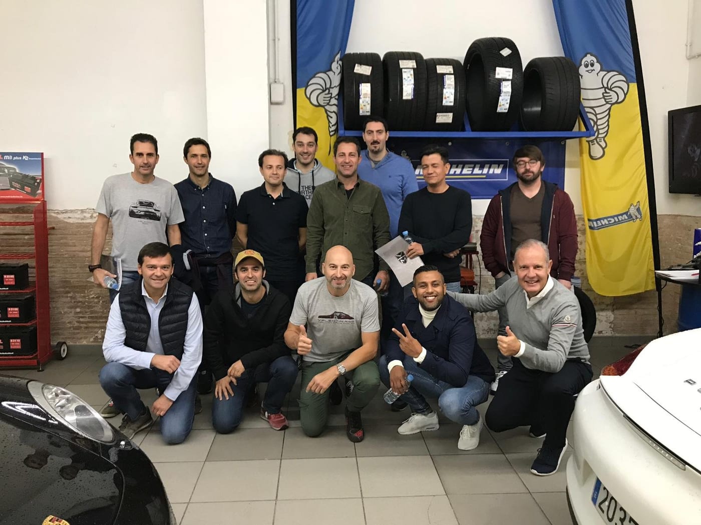 Foto de grup del II Endurance al taller, davant l'expositor de pneumàtics