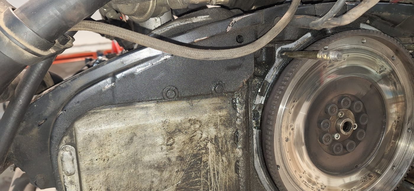 El volante motor del 3.2 serie G al descubierto, con la chapa de fondo sucia de aceite