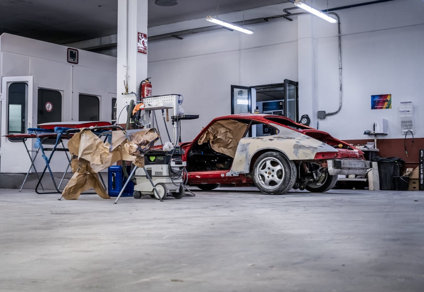 Porsche 964 rouge masquée pour la peinture près de la cabine du centre de Leganés