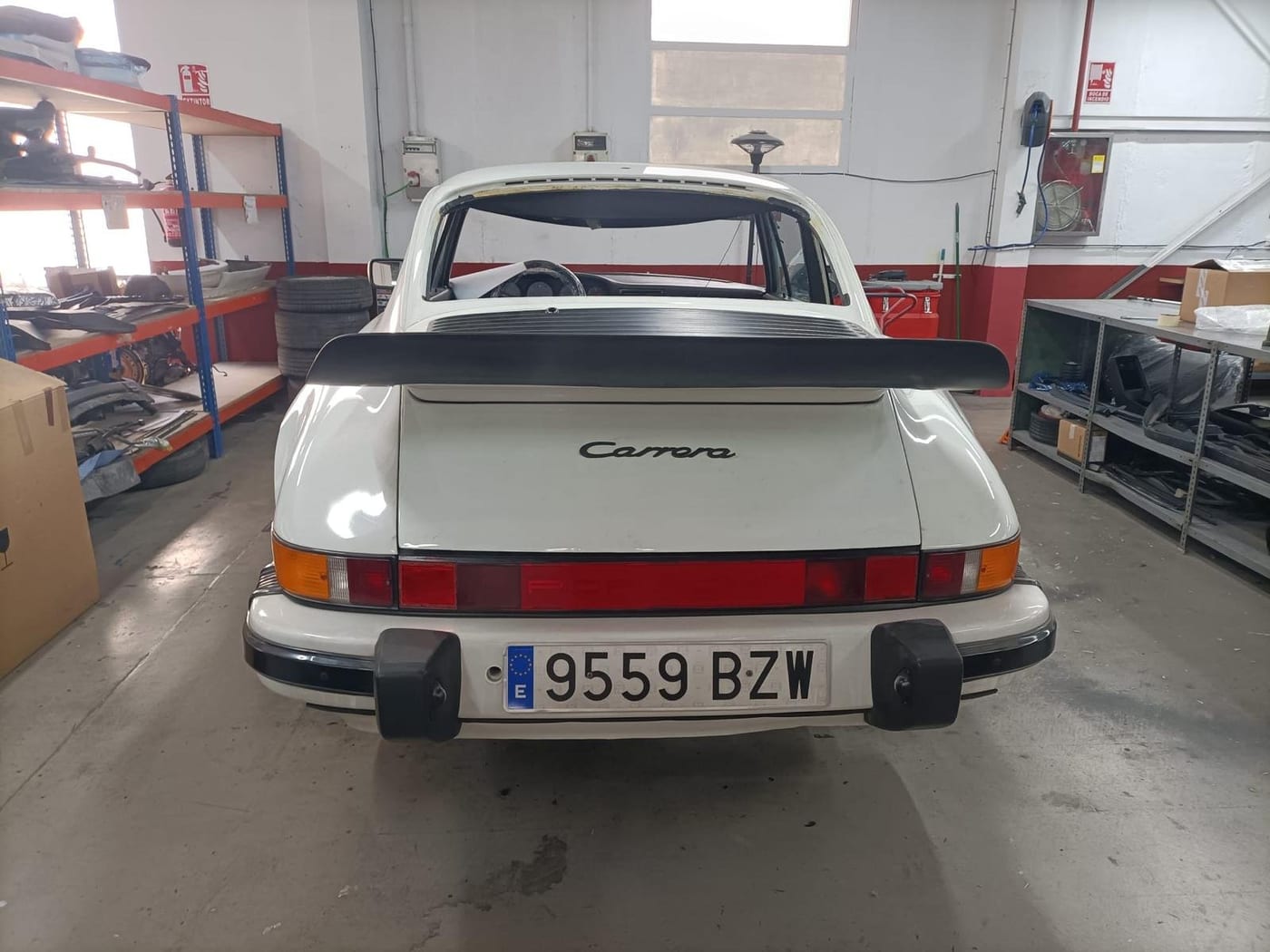 Rear of the white G-series 911 Carrera with the ducktail spoiler, in the workshop