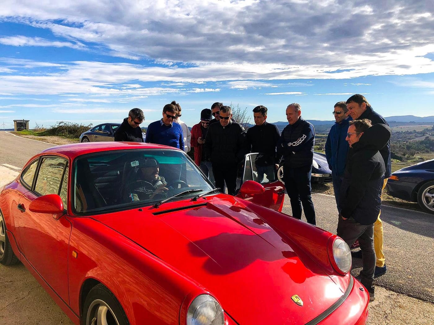 Els participants del III Endurance envolten un 964 Carrera vermell en una parada de la ruta