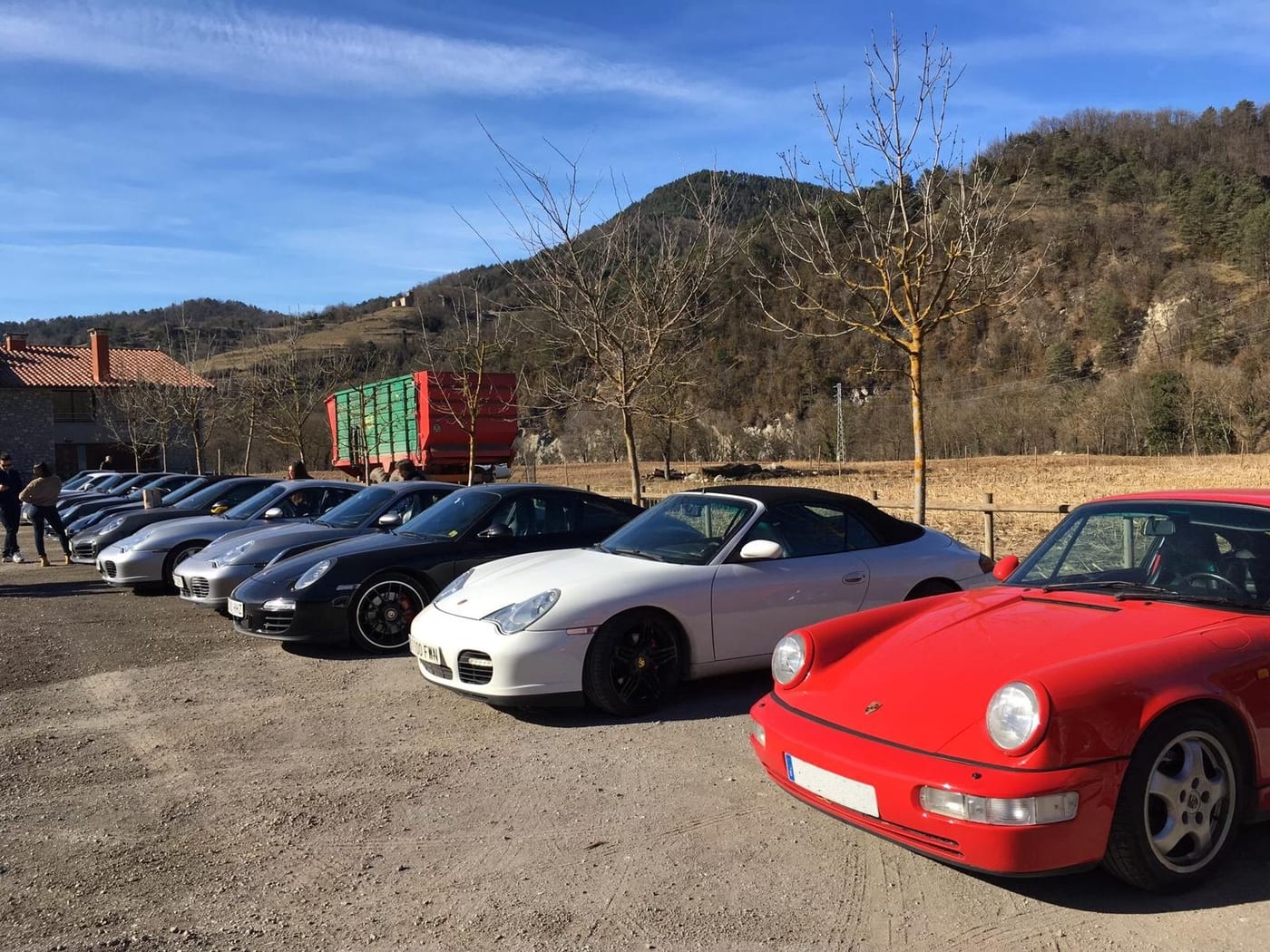 Els Porsche del IV Endurance aparcats en una plana entre muntanyes, amb un 964 Carrera vermell en primer pla