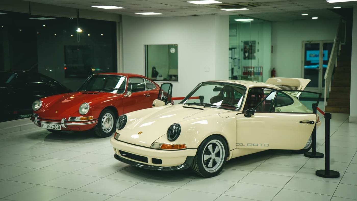 El 911 PA10 crema junto a un 911 rojo de serie F en la sala de exposición