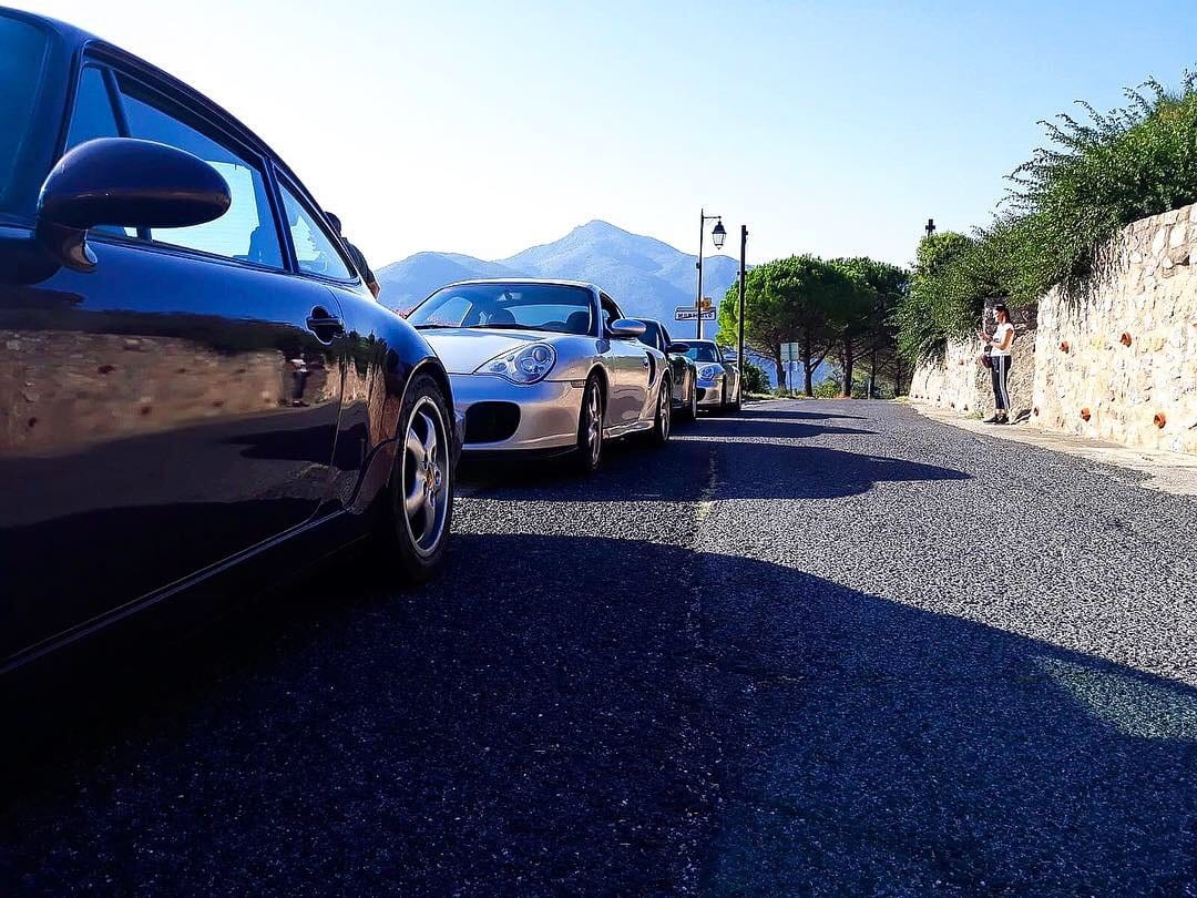 Un 996 blau i un Boxster aparcats al costat d'un mur de pedra, al II Endurance
