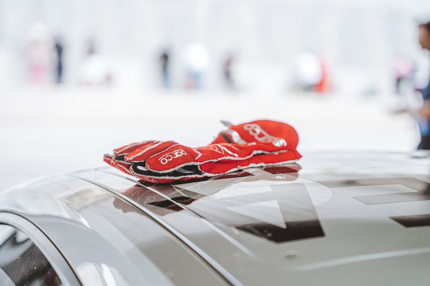 Guantes de competición rojos sobre el capó del 991 Cup de Valentín Motors