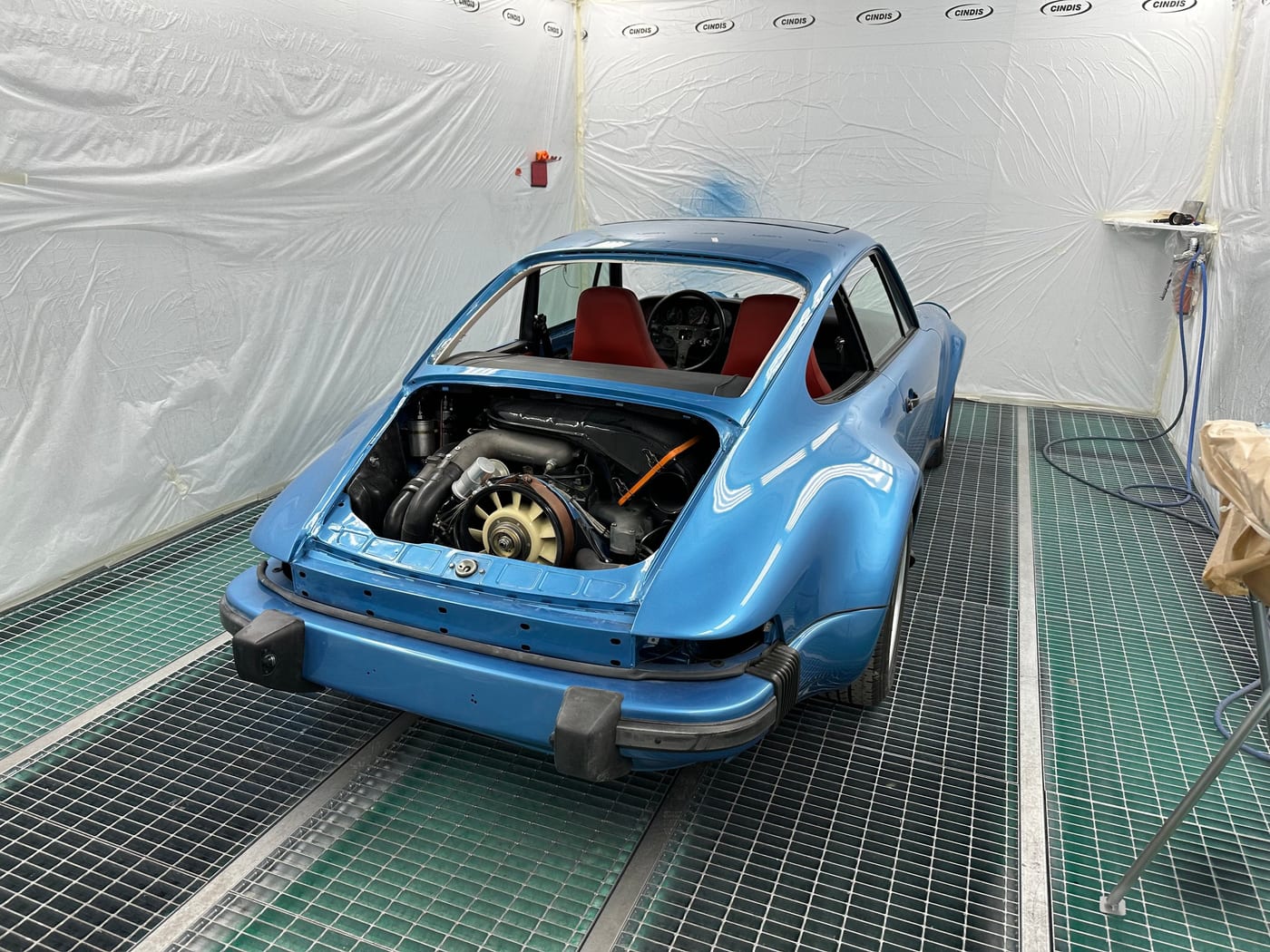 La 930 Turbo bleue fraîchement peinte en cabine, compartiment moteur ouvert