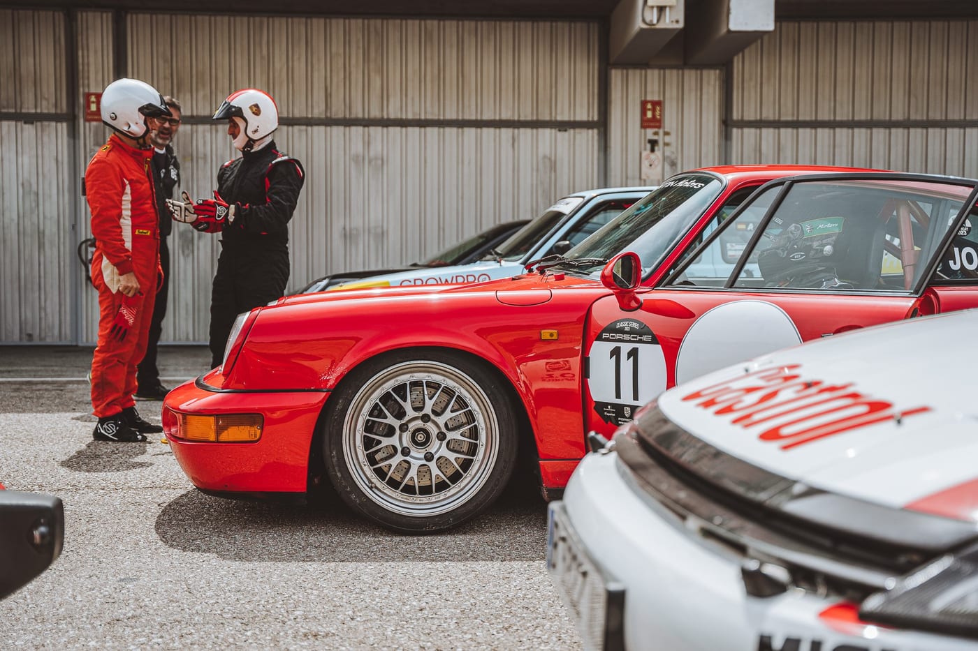 Dos pilotos conversan junto al 964 número 11 en el pit lane