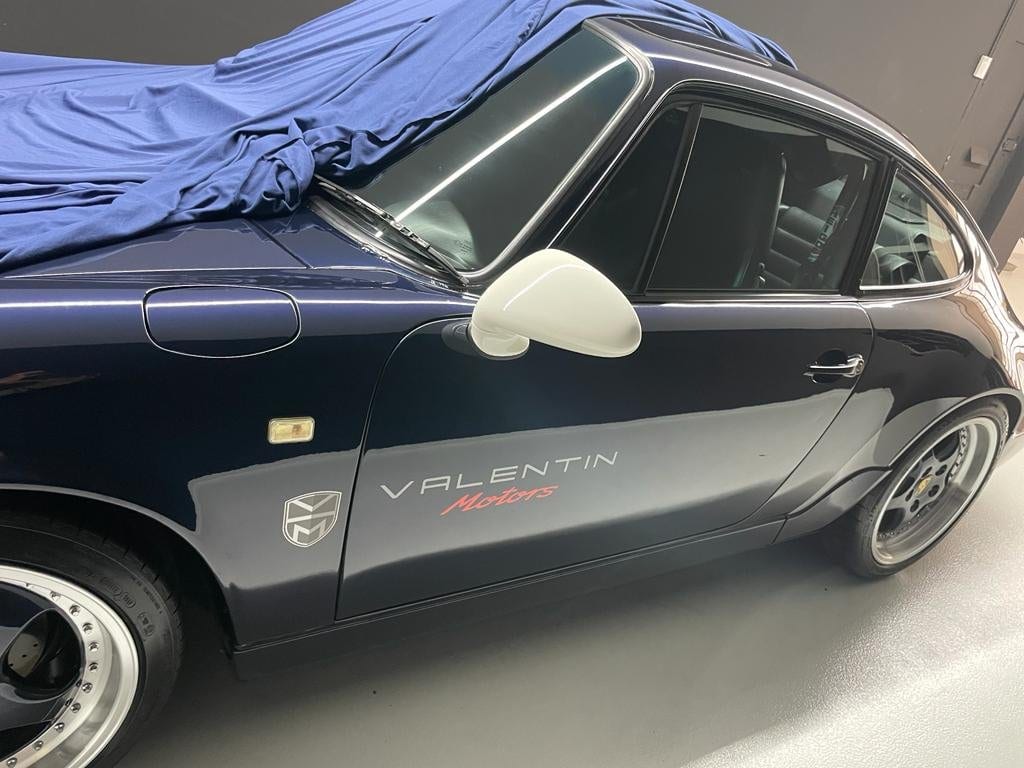 Lateral del 964 azul noche con retrovisor blanco y la funda a medio retirar