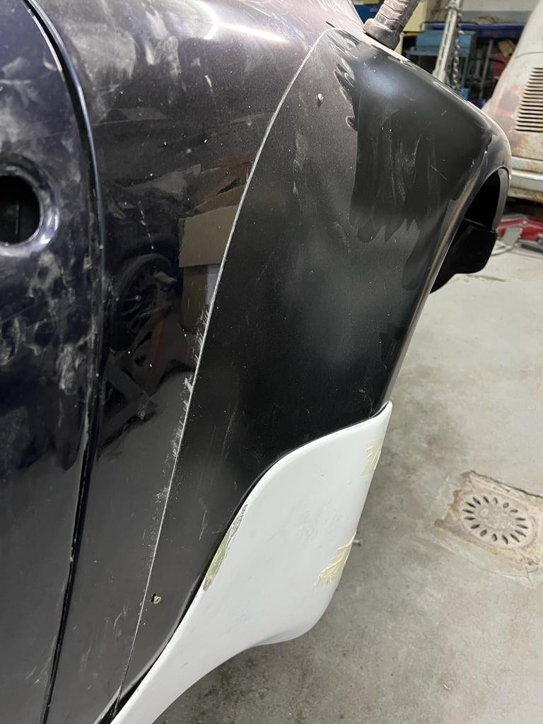 Frontal del 964 con el paragolpes desmontado y una pieza blanca en pruebas de ajuste