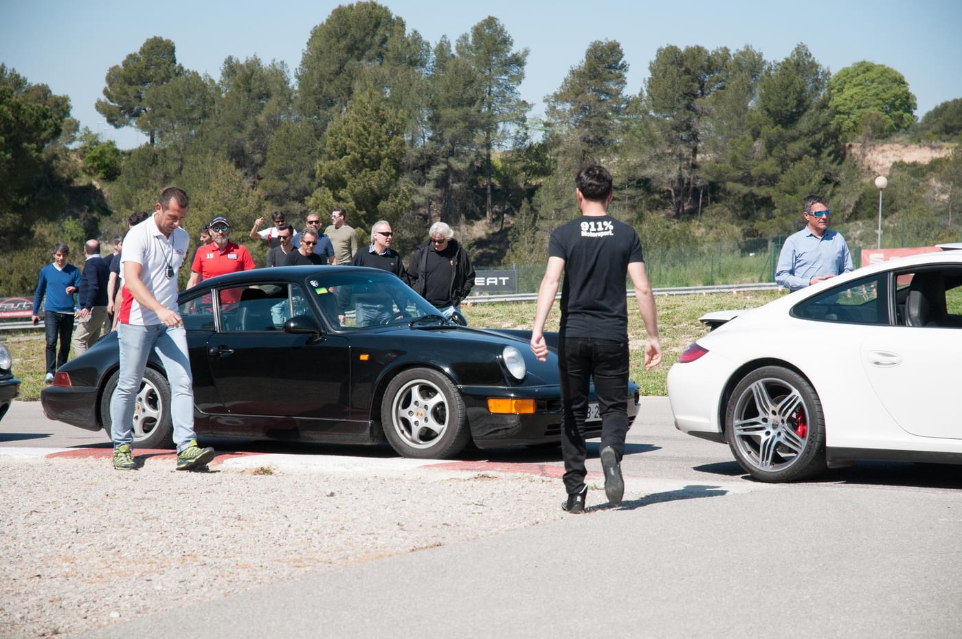 Els participants del Summer Ride 2017 al voltant d'un 964 negre al paddock
