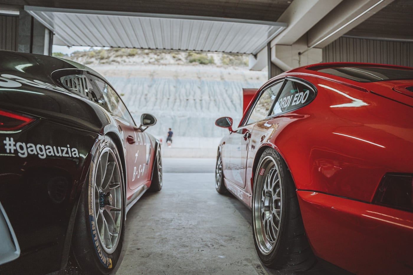 Zagas de dos Porsche de competición rotulados en el box del circuito