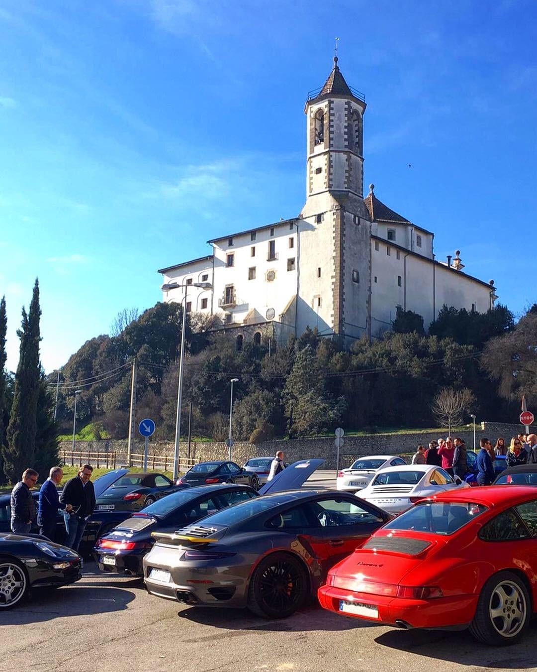 Parada del IV Endurance al peu d'una església encalada, amb els participants al costat dels cotxes