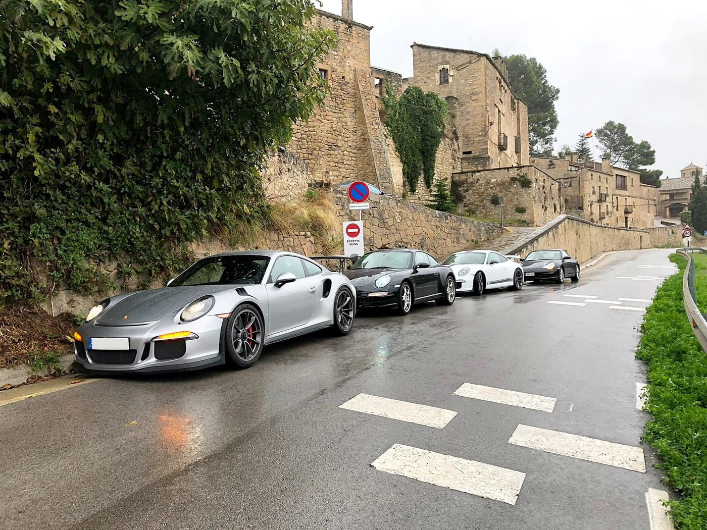 Els Porsche del II Endurance aparcats al costat d'una muralla, amb un 991 GT3 RS plata davant