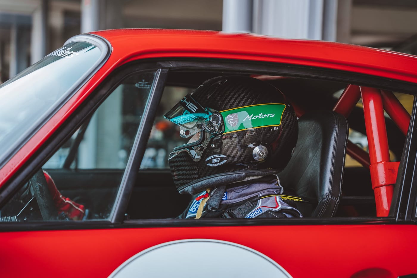 El casco sobre el asiento del 964 rojo, con la puerta abierta