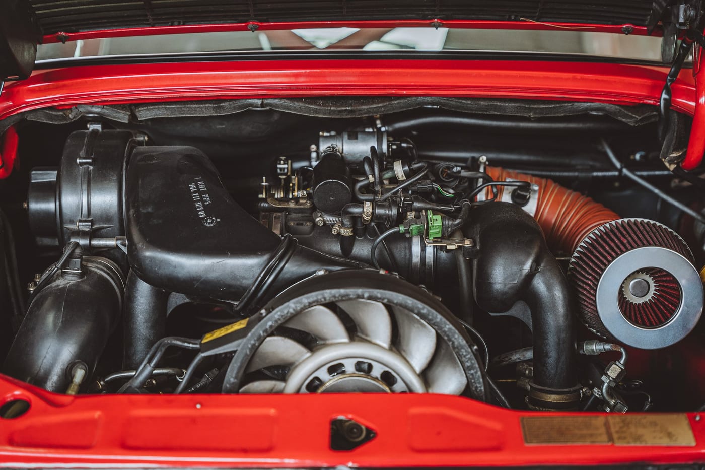 Vano motor del 964 de competición con el filtro cónico y los conductos a la vista