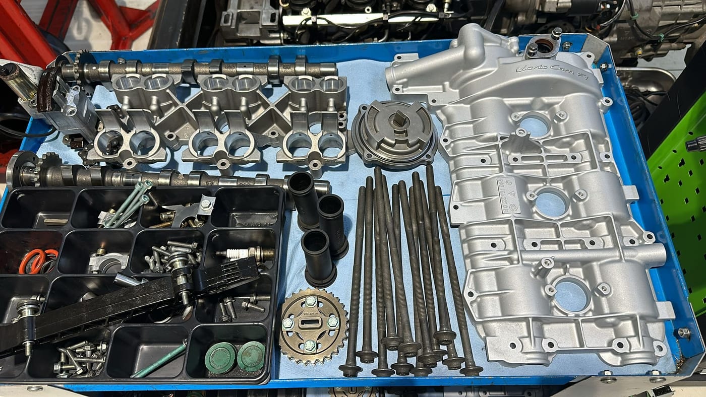 Complete M96 teardown sorted into trays: camshafts, cylinder head and hardware