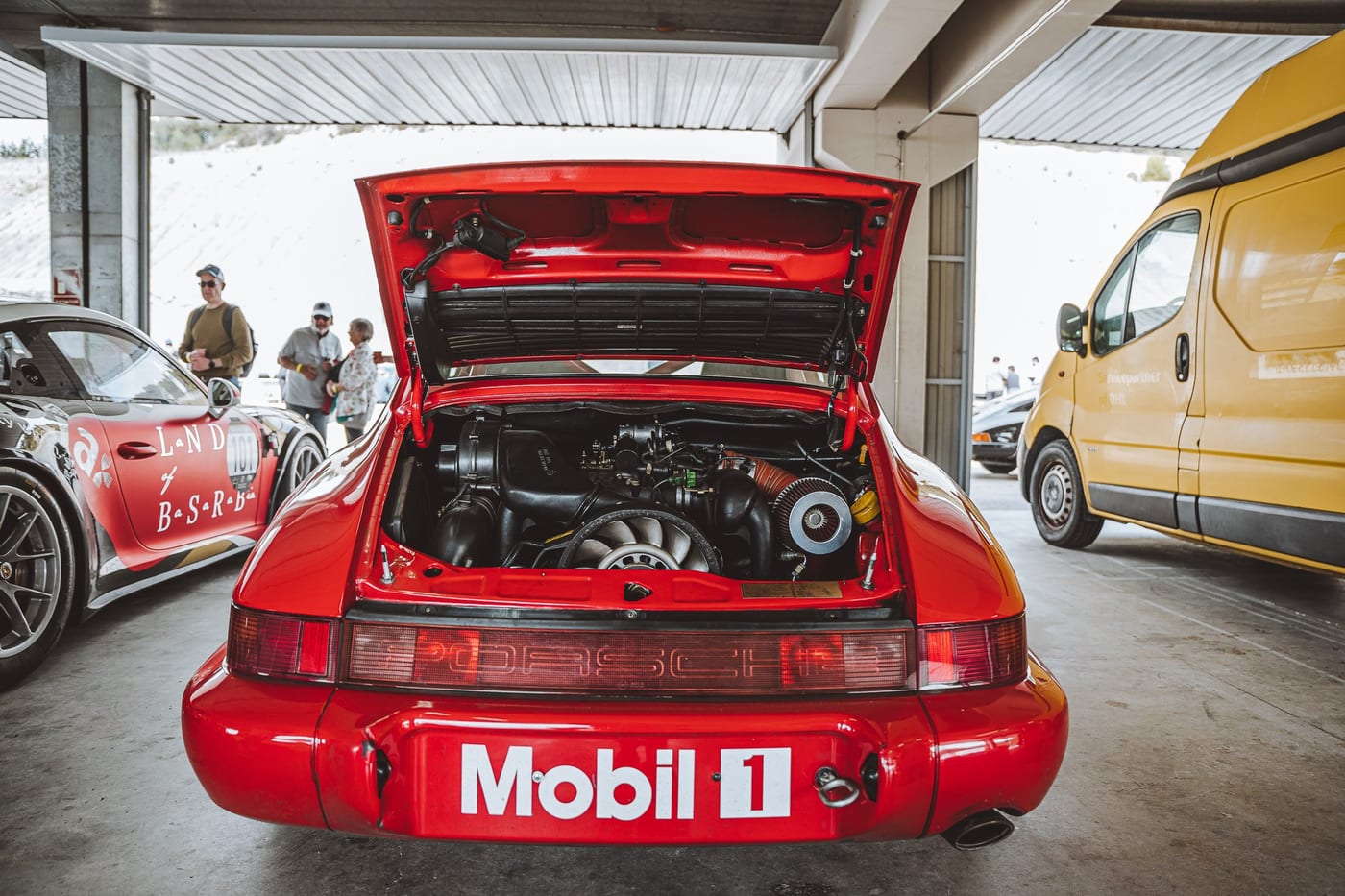 El 964 rojo con la tapa del motor levantada en el pit lane
