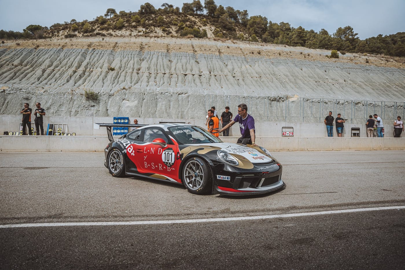El 991 Cup número 101 en pista, con los comisarios tras el muro