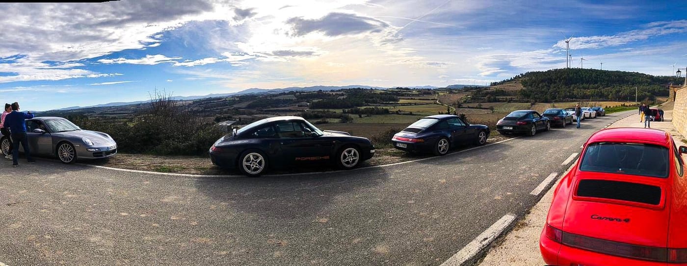 Panoràmica del III Endurance en un alt, amb un 993 blau i un 964 Carrera 4 vermell sobre camps de conreu
