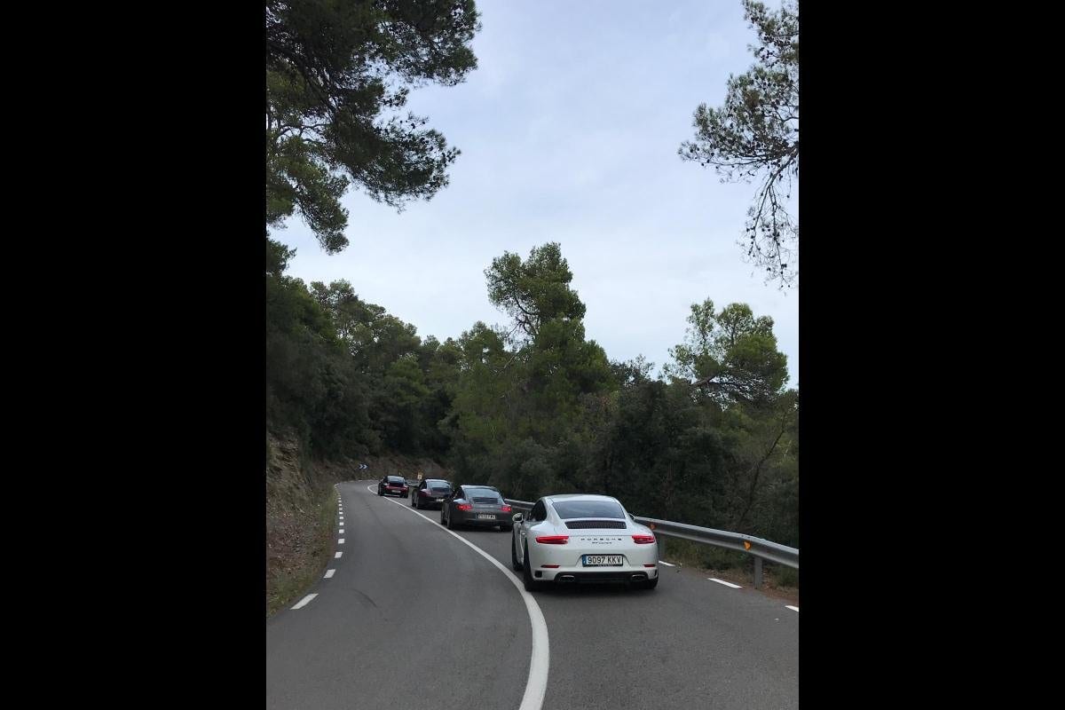 Un 991 Carrera blanc tanca la filera per una carretera entre pins al VI Endurance