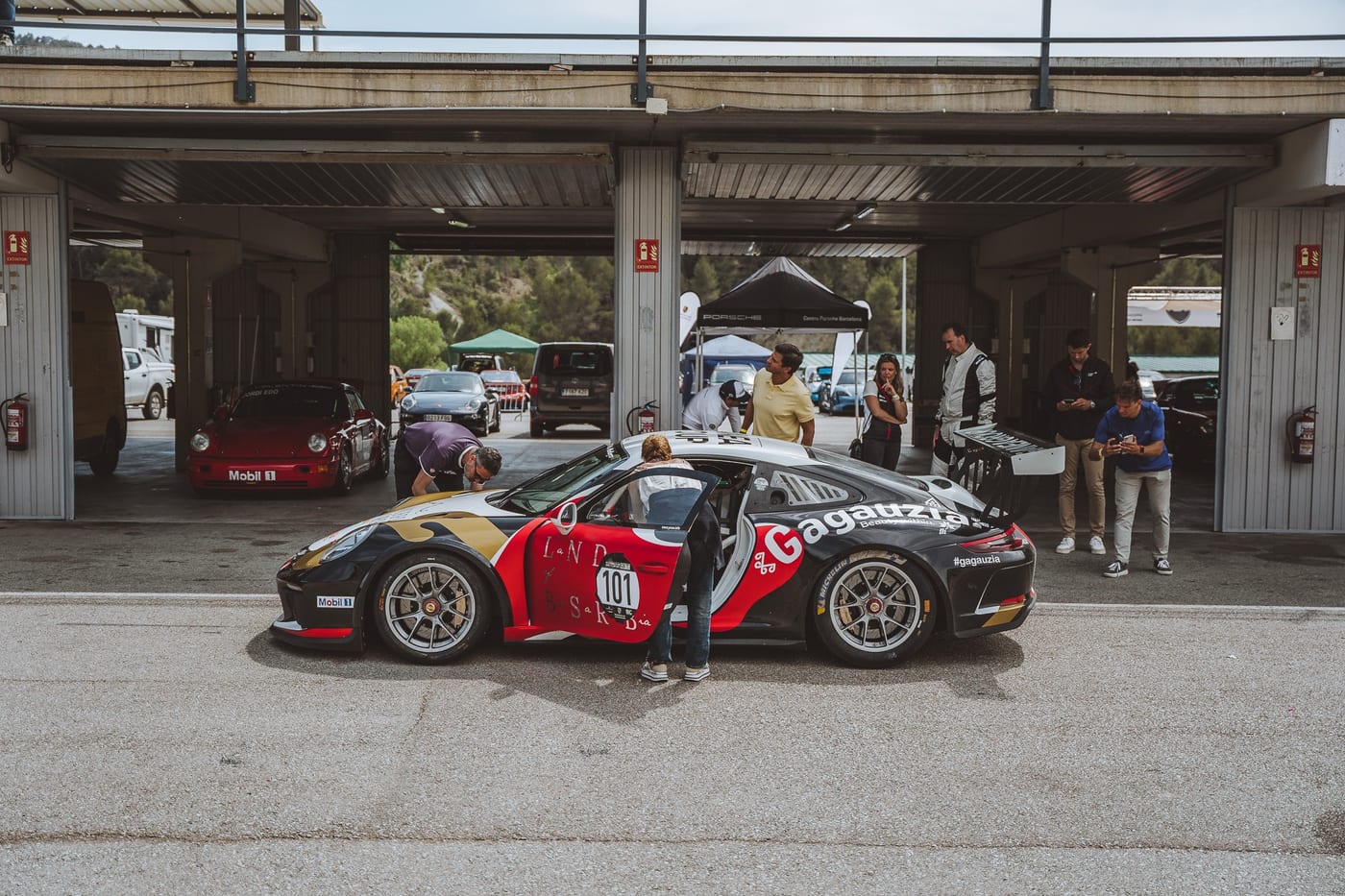 El 991 Cup número 101 en el paddock, con el ambiente de la carrera alrededor