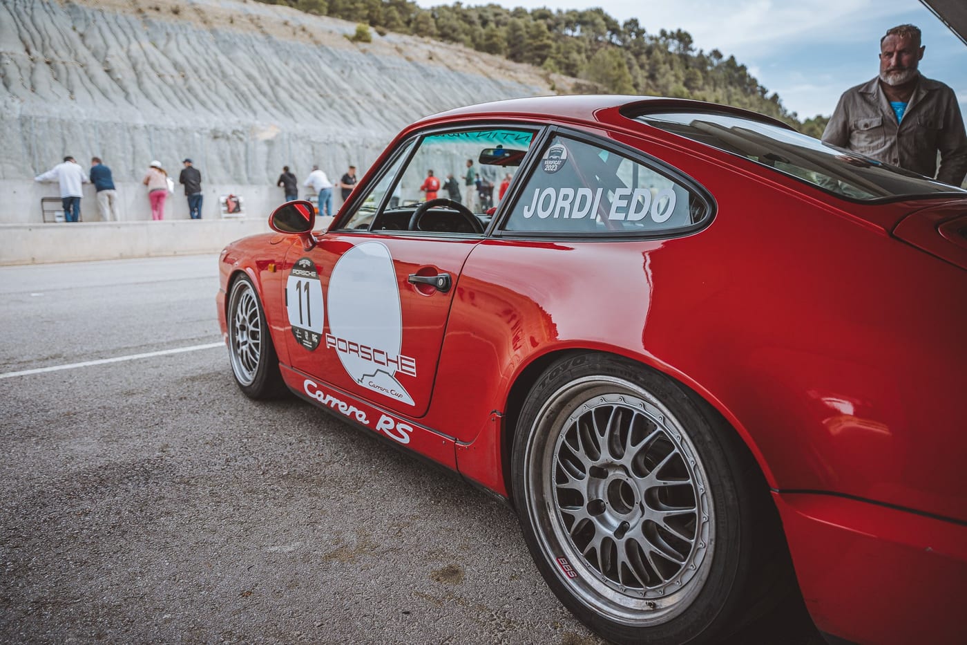 El 964 Carrera RS número 11 en el paddock, con el público al fondo