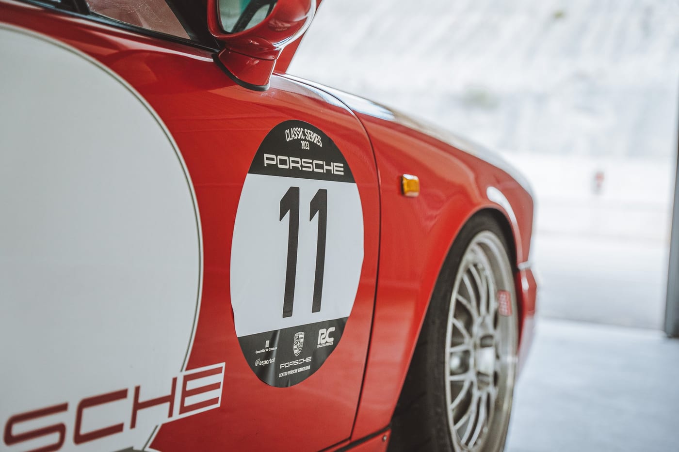 El dorsal 11 y el logotipo Porsche sobre el flanco del 964 Carrera RS rojo