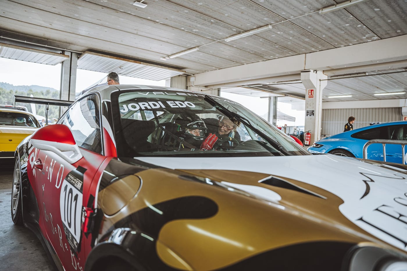 El 991 Cup con el piloto a bordo, listo en el box entre los demás coches