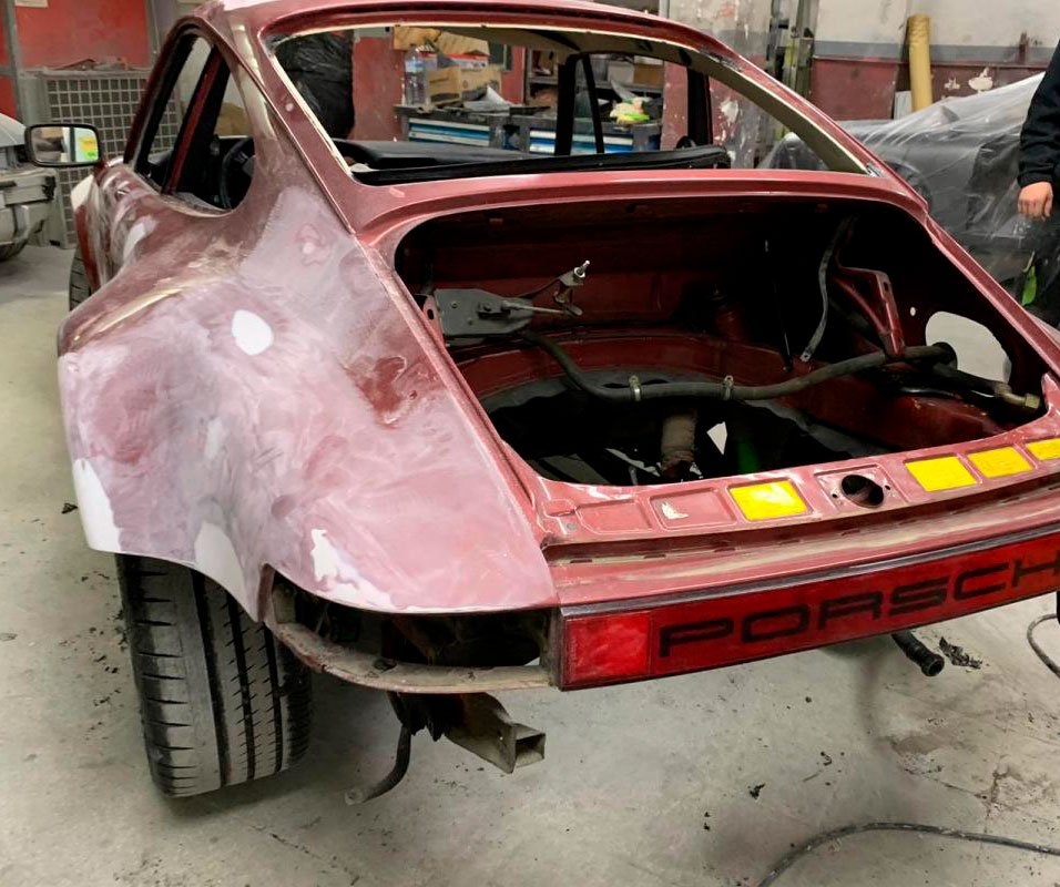 Carrocería de un 911 con la aleta trasera en masilla, preparándose en el taller de chapa