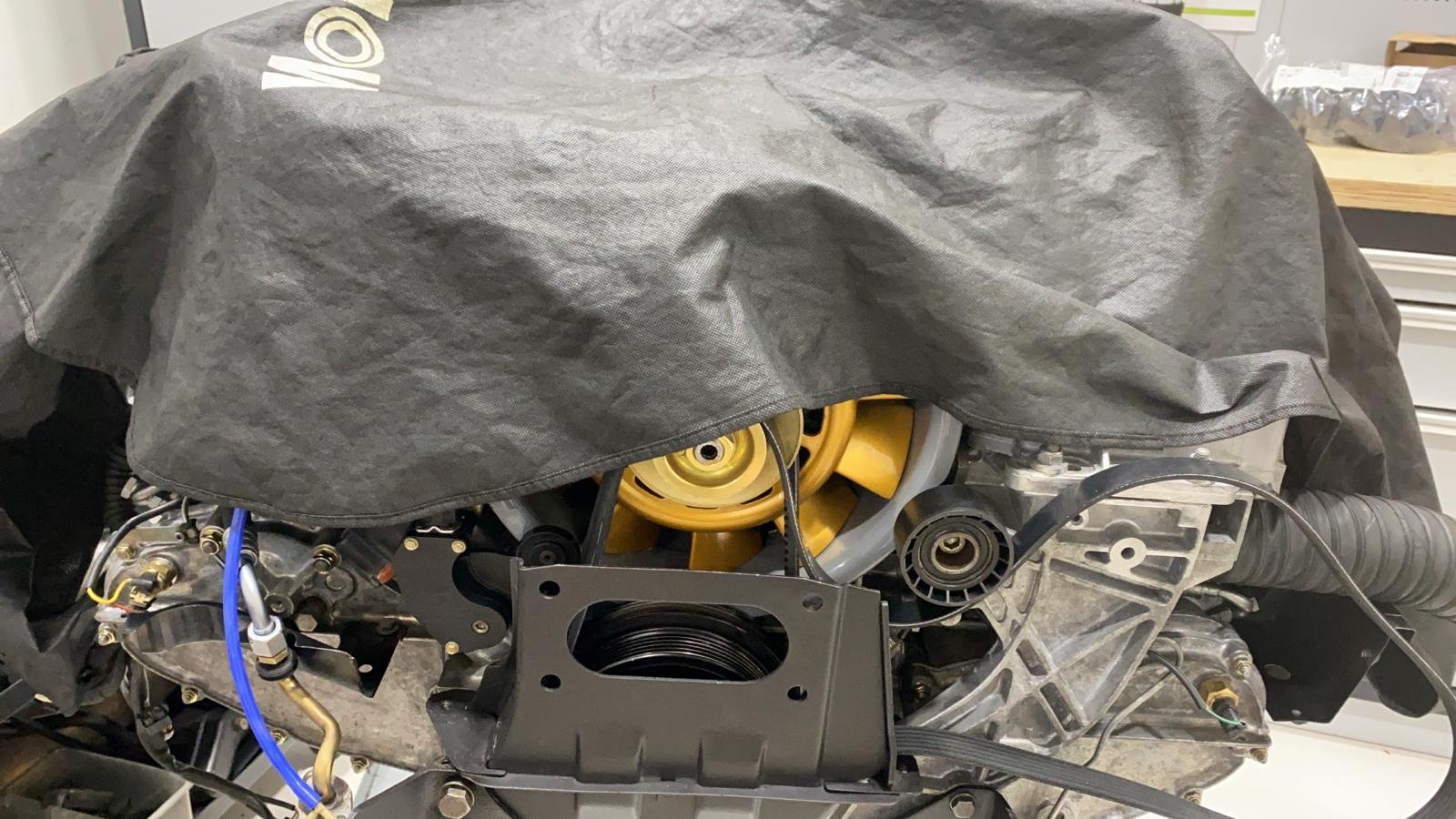 Motor de un 930 Turbo 3.0 de 1988 en el vano, con el ventilador dorado asomando bajo la funda