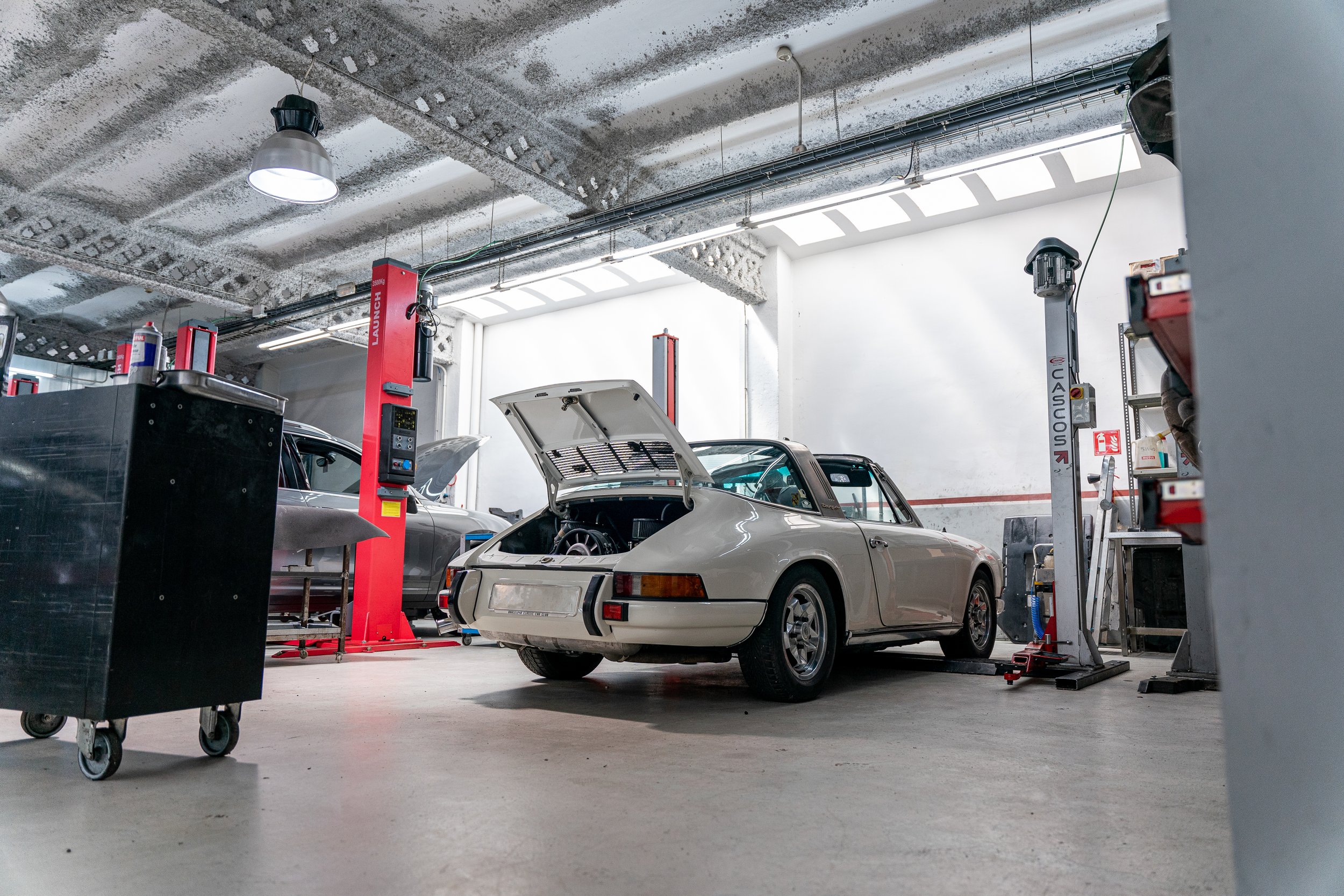 Porsche 911 clásico sobre el elevador con el capó abierto